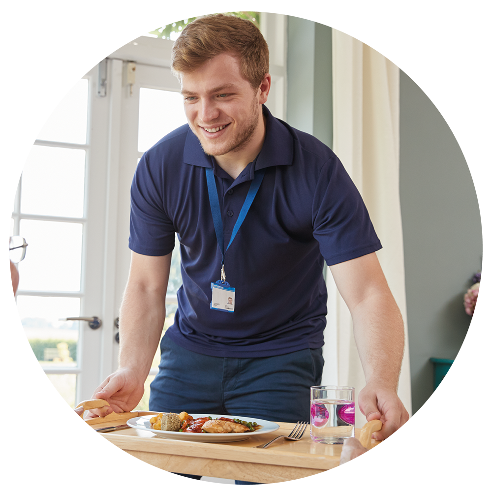 A carer bringing a meal to a client using home care services.