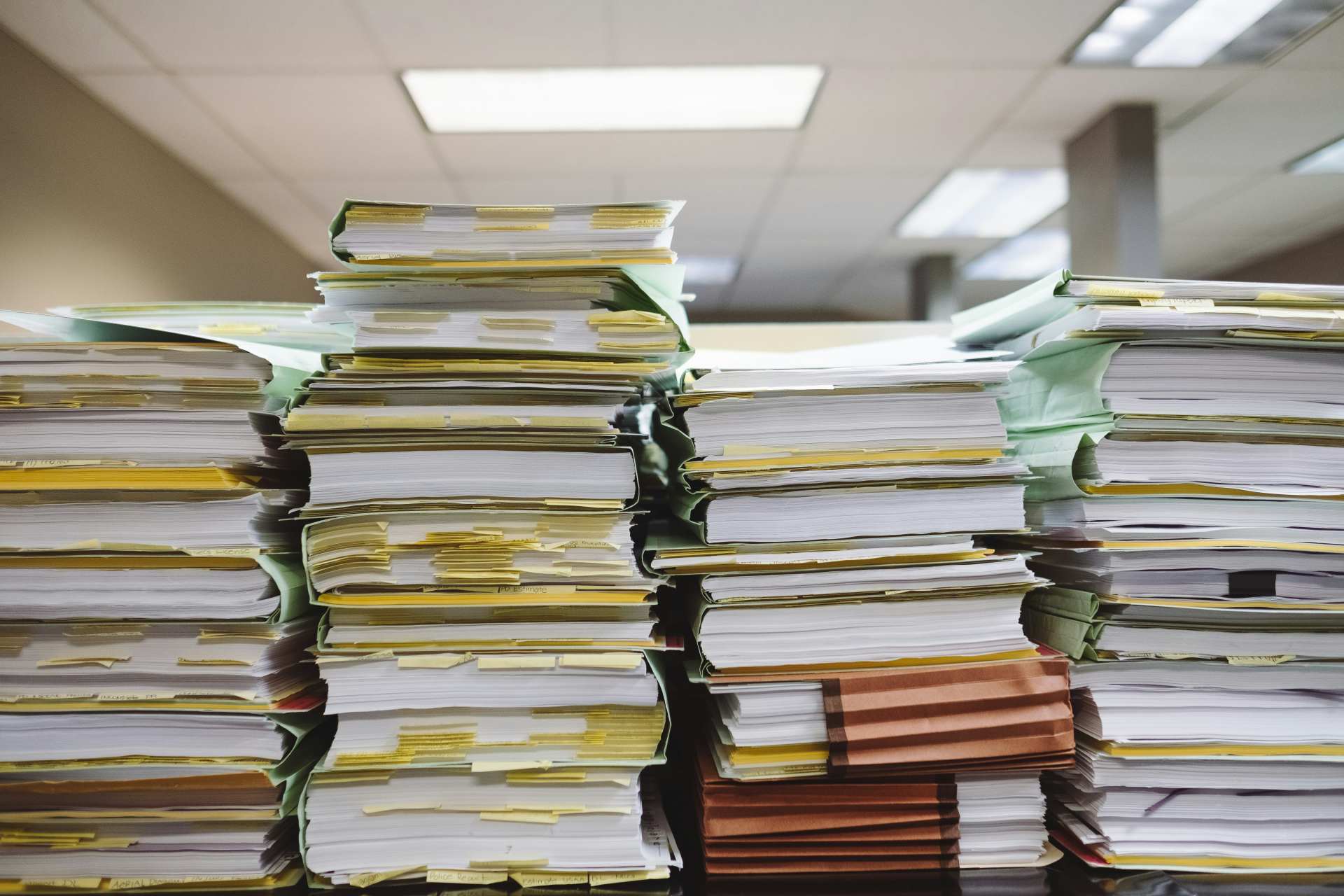 Avoid the paperwork overwhelm with digital care planning. Image of piled-up paperwork in an office.