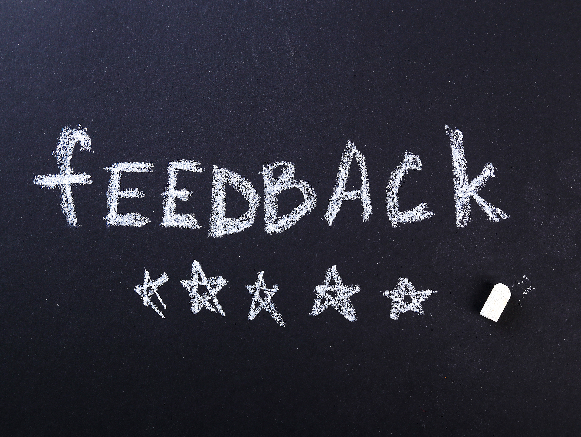 The word Feedback with 5 stars drawn underneath, all done in chalk.