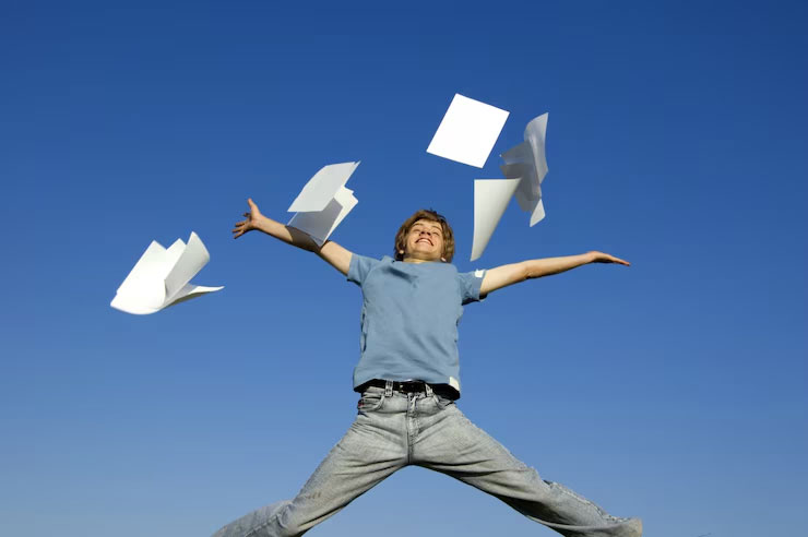 A man leaping in the air while throwing away his paperwork. Domiciliary care software can help eliminate paperwork.