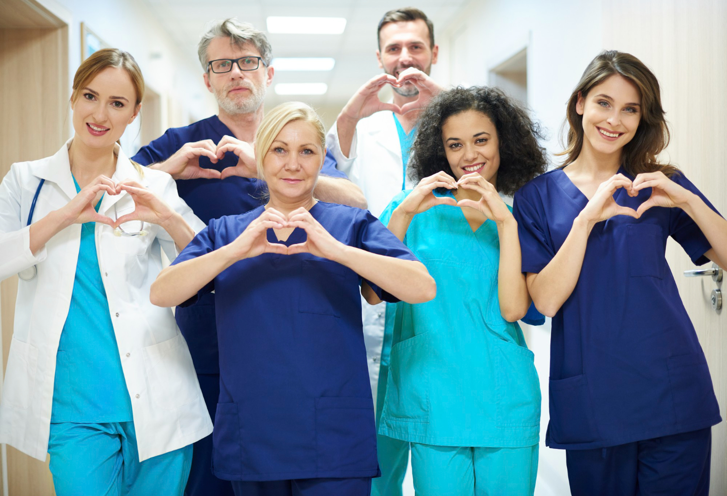 A home care team making heart shapes with their hands